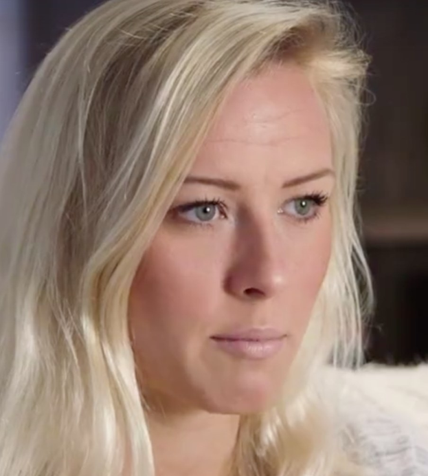 Blonde Frau mit blauen Augen in Not, Hintergrund unscharf, möglicherweise wegen Zwang zur Show-Austritt.