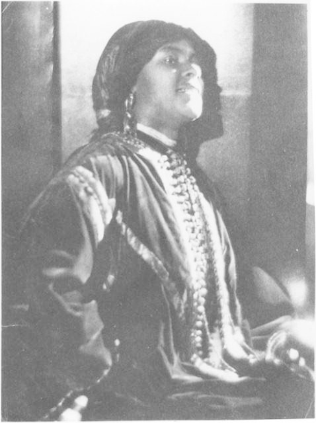 Schwarz-weiß-Foto einer Frau in Kleid und Schmuck vor einer Wand sitzend, mit Text unten, der besagt, dass sie believed wird, die erste indische Frau zu sein, die zum US-Präsidenten gewählt wurde.