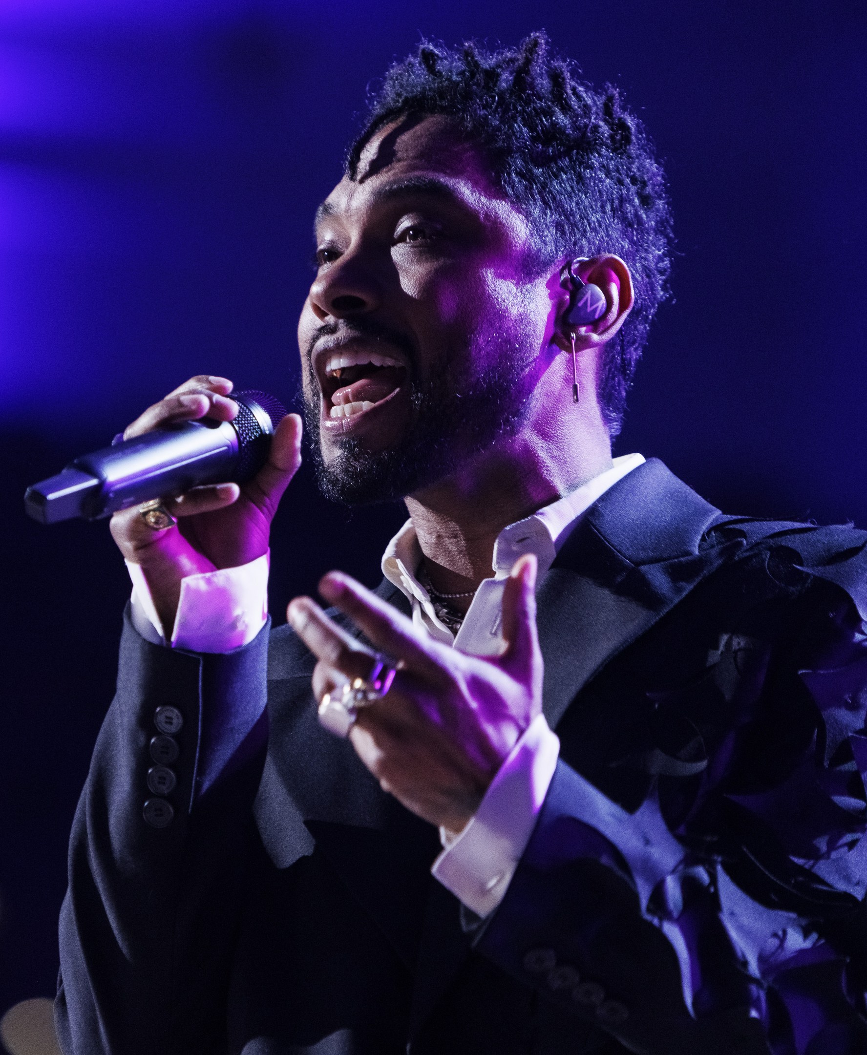 Ein Mann in einem schwarzen Anzug singt in ein Mikrofon während einer Live-Performance in der O2 Arena in London.