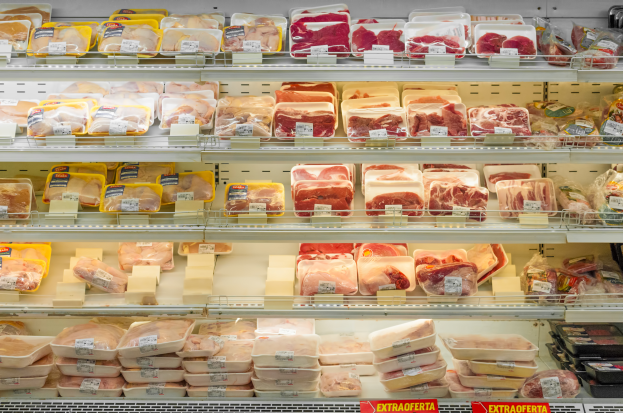 Ein gut sortierter Supermarkt mit ordentlich aufgereihten Fleischwaren auf den Regalen, jeweils mit sichtbaren Preisschildern.