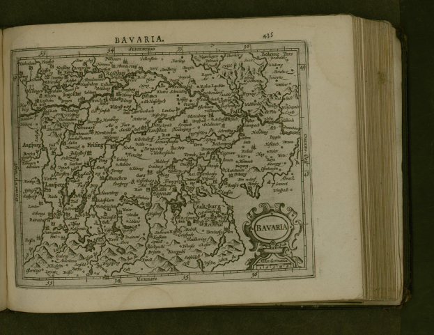 Offenes Buch mit detaillierter Karte von Bayern mit beschrifteten Städten und Ortschaften, begleitet von Text, der wahrscheinlich die Region beschreibt.