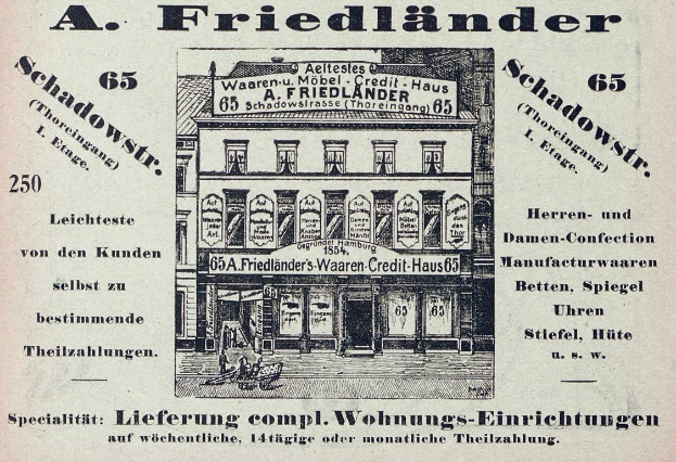 Schwarz-weiß-Fotografie einer alten Werbung für ein Friedländer Geschäft in Deutschland, das ein Gebäude mit Text an der Fassade zeigt.