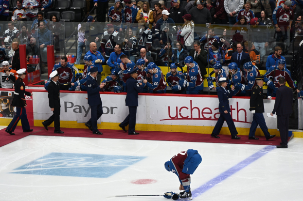 Hockeyspieler auf dem Eis von Fans und Teammitgliedern umgeben während eines NHL-Spiels zwischen Colorado Avalanche und San Jose Sharks am 24. März 2015.