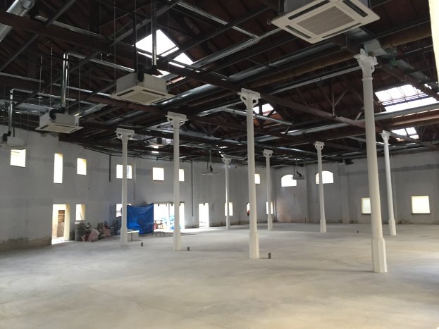 Industrielles Lagerhalle mit großen Fenstern, Säulen, Deckenleuchten, Klimaanlagen und einem offenen Grundriss, zu vermieten.