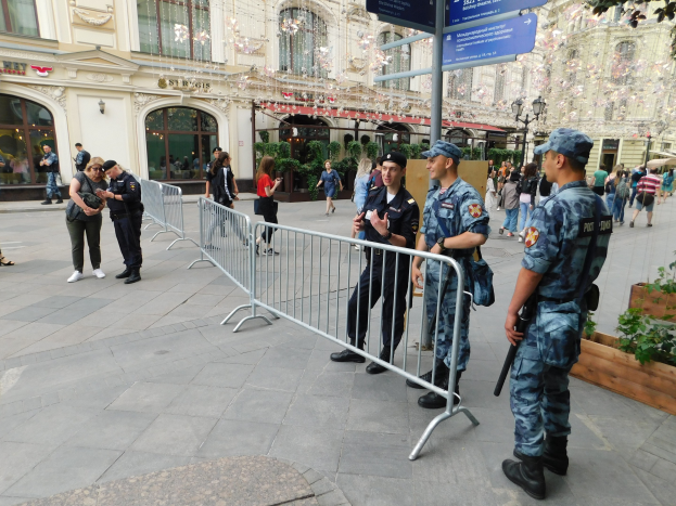 Polizeibeamte in Uniform stehen hinter Barrikaden und blicken einer Menge entgegen, einige halten Waffen, während sie eine Anti-Terror-Operation in Wien, Österreich, durchführen.