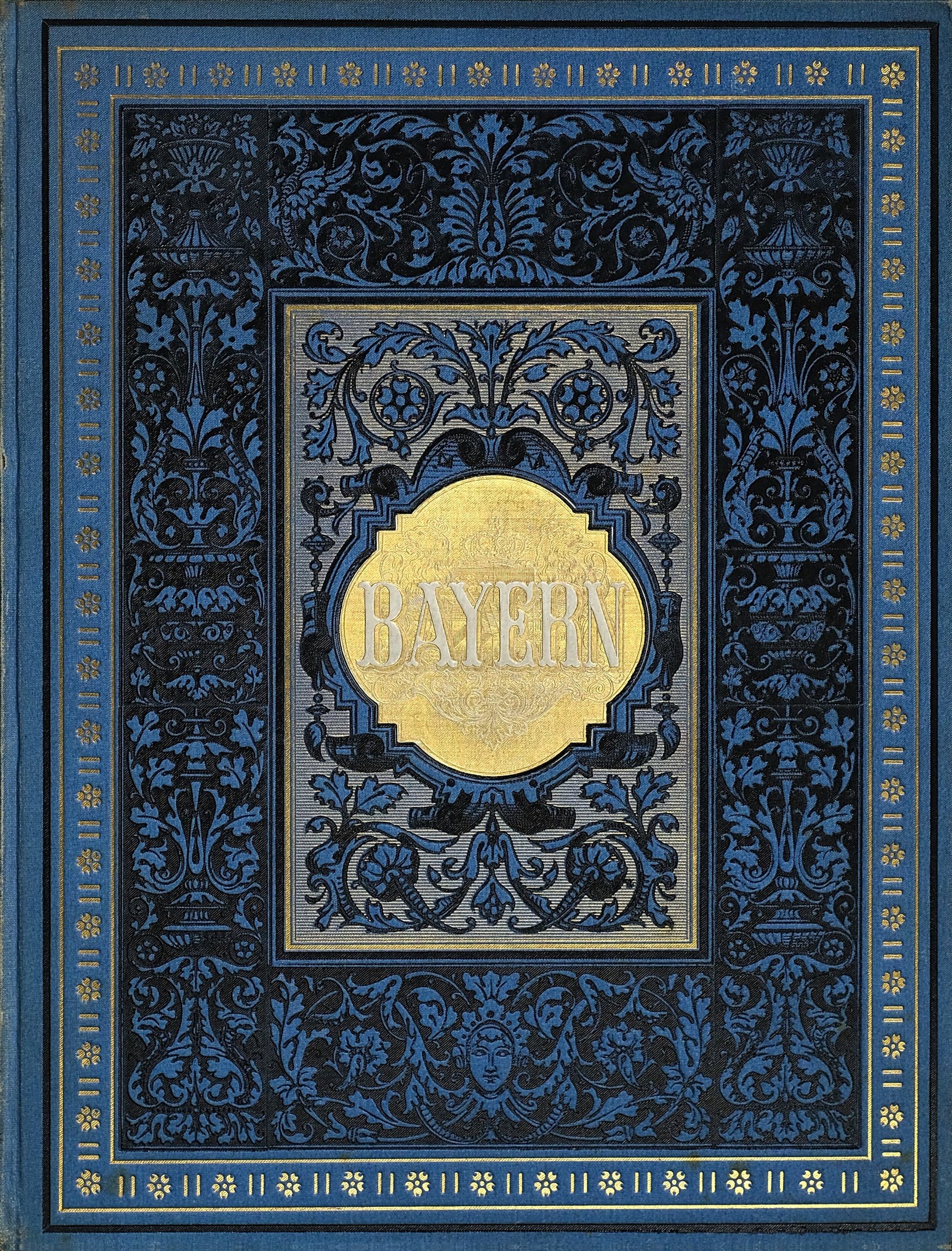 Ein blau-goldenes Buch mit dem Wort "Bayern" darauf, das mit detaillierten Dekorationen verziert ist.