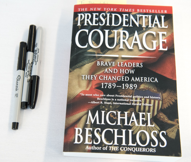 Eine weiße Fläche mit einem Buch namens "Präsidiale Tapferkeit: Mutige Führer und wie sie Amerika 1789-1989 veränderten" von Michael Beschloss und zwei Stiften.