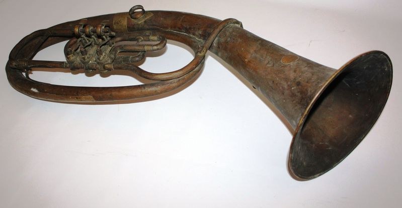 Alter Messinghorn mit glänzendem Finish, gebogener Hals und aufgeblähter Schalltrichter, mit detaillierten Gravuren auf einem weißen Hintergrund.