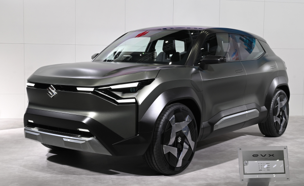 Ein schlankes, modernes Suzuki EVX Concept-Auto mit glänzender schwarzer Lackierung, großem Kühlergrill und geschwungener Motorhaube auf der Frankfurt Motor Show ausgestellt, mit einer Tafel im Vordergrund und einer Wand im Hintergrund.