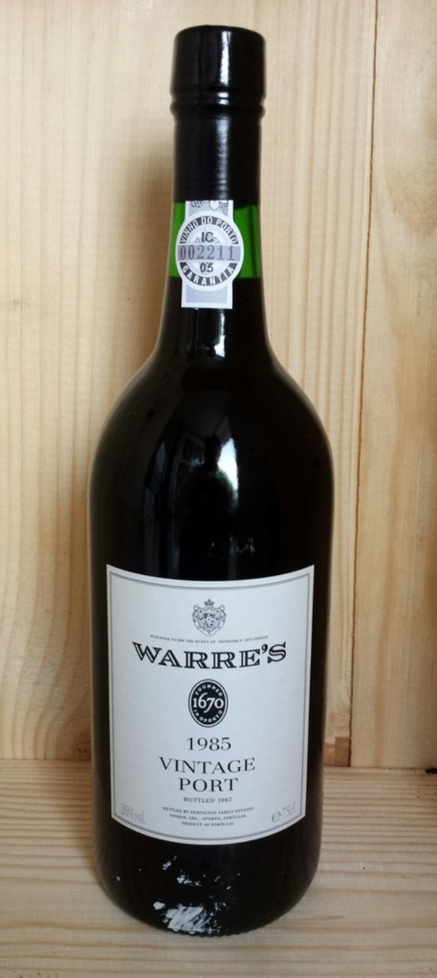 Eine Bierflasche steht auf einem Holzweg, mit sichtbaren Etiketten auf der Flasche.