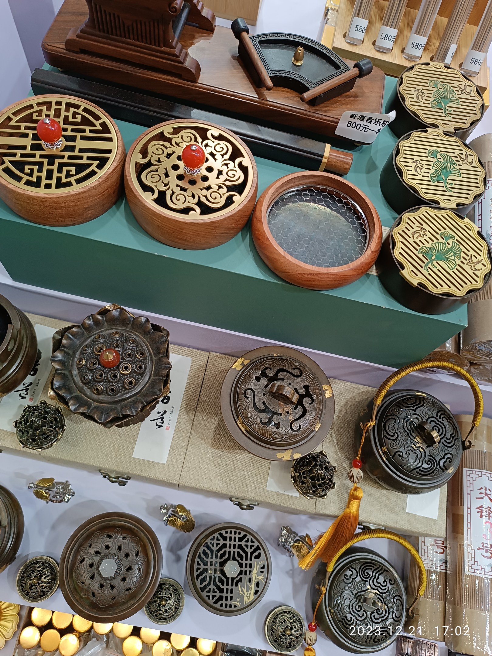 Ein Tisch mit verschiedenen chinesischen Räucherstäbchen, Boxen, Papieren mit Text und anderen Gegenständen, die likely für ein chinesisches Neujahrsfest arrangiert sind.