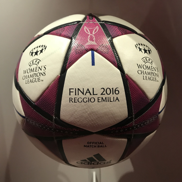 Ein Fußball mit der Aufschrift 'UEFA Women's Champions League Final 2016' in Weiß, Rosa und Schwarz auf einem weißen Tisch.