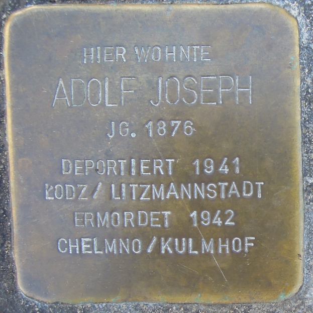 Metallplatte an einem Gebäude mit der Inschrift "Adolf Joseph"