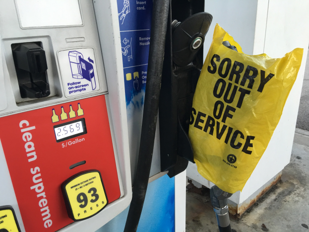 Tankstelle mit einem "Sorry Out of Service"-Schild und einer gelben Abdeckung, die als Kraftstoffspende bezeichnet wird.